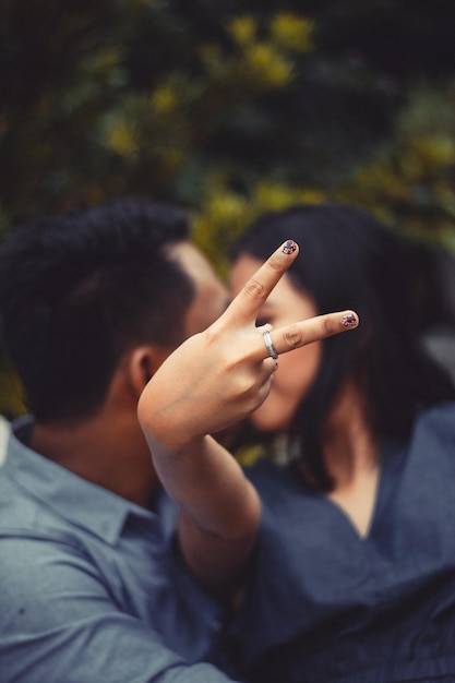 男性にキスする際に平和のサインを示す女性