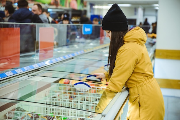 Photo woman get products from the fridge in supermarket