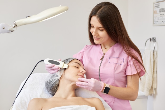 Женщина получает очищающую терапию с помощью профессионального ультразвукового оборудования