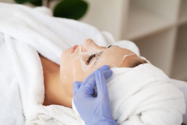 Woman gets a face mask in a beauty salon