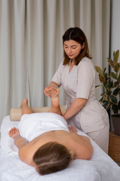 Photo woman getting a back massage from female masseur