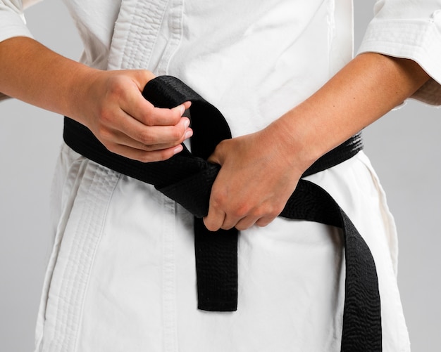 Photo woman getting dressed in uniform and black belt