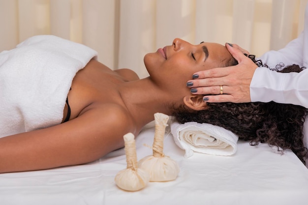 Photo woman getting face massage with chinese pindas