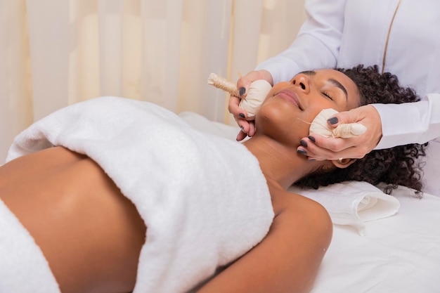 Woman getting face massage with chinese pindas