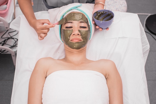 Woman getting facial care by beautician