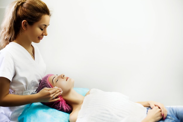 Woman getting facial care in spa salon