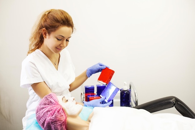 Woman getting facial care in spa salon