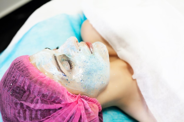 Woman getting facial care in spa salon