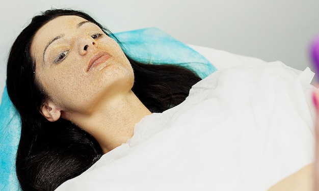 Woman getting facial care in spa salon