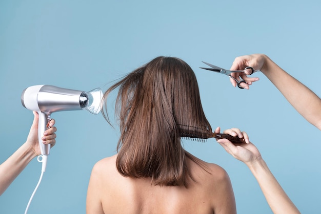 Woman getting a haircut and blow drying her hair