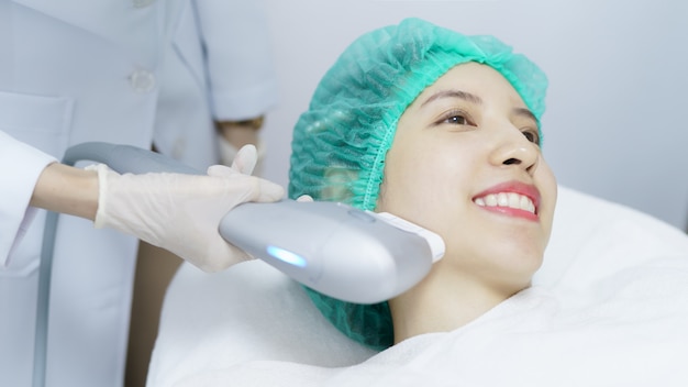 Woman getting Hifu spa treatment, girl receiving  ultra former massage face.