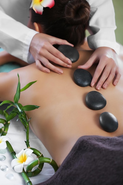 Woman getting a hot stone massage at spa salon