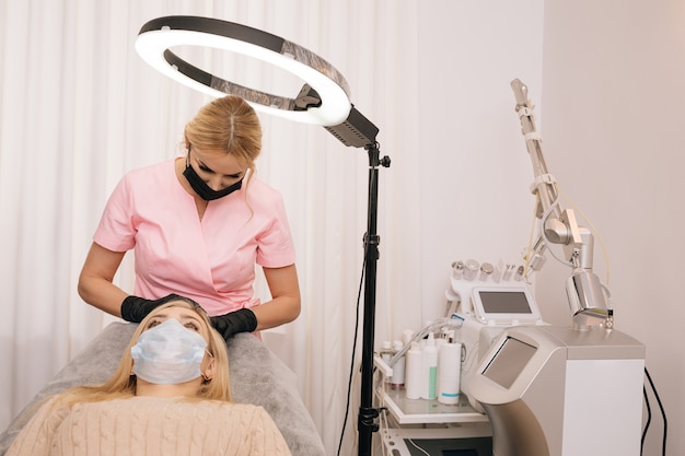 Женщина получает инъекцию в кожу головы мезотерапия терапия выпадения волос Врачи в перчатках в салоне делают медицинские манипуляции пациенту