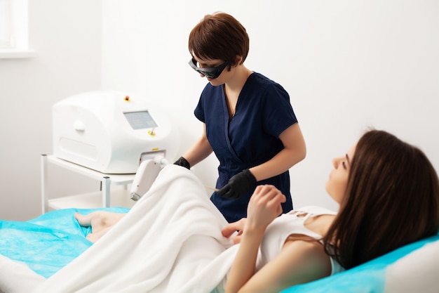 Woman getting laser treatment in a beauty salon.