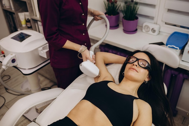 Woman getting laser treatment on her armpit in a beauty salon close up