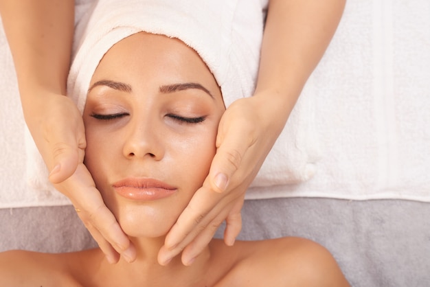 Photo woman getting massage for face