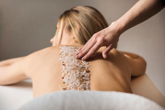 Photo woman getting massage with sea salt in spa