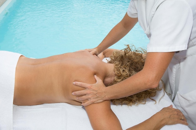 Woman getting a shoulder massage in spa center