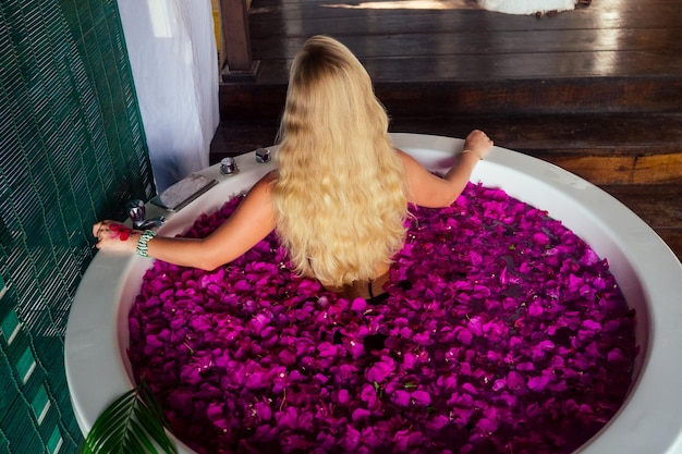 Woman getting tropical bath in paradise spa resort