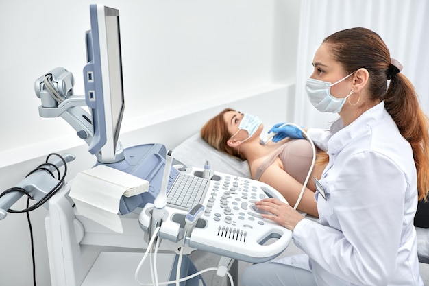 Woman getting ultrasound of a thyroid from doctor