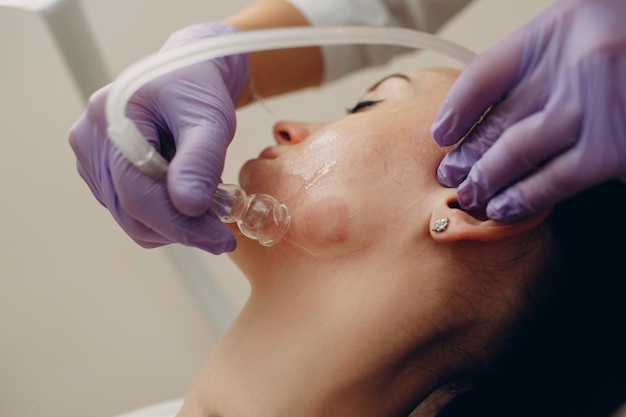 Woman Getting Vacuum Cleaning Face Treatment At Beauty Clinic or Spa