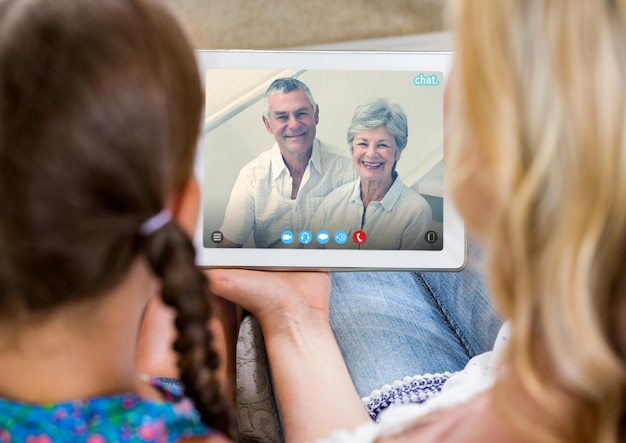 디지털 태블릿으로 노부부와 영상 통화를 하는 여성과 소녀