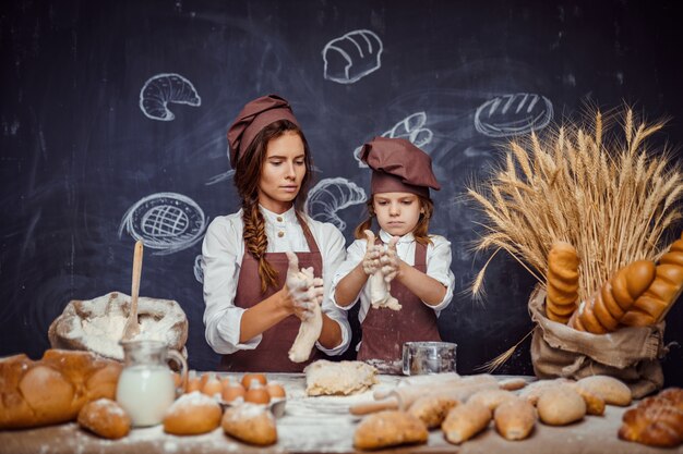 Donna e ragazza che producono insieme le pasticcerie