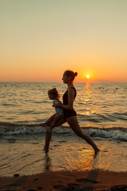 Woman and girl silhouette practicing balancing yoga