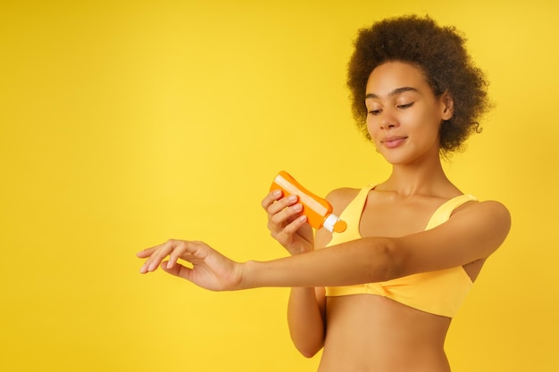 Woman girl spreads sunscreen to protect herself from the sun