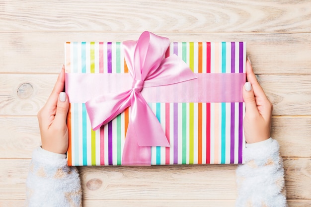 Woman gives Valentine gift box with pink bow