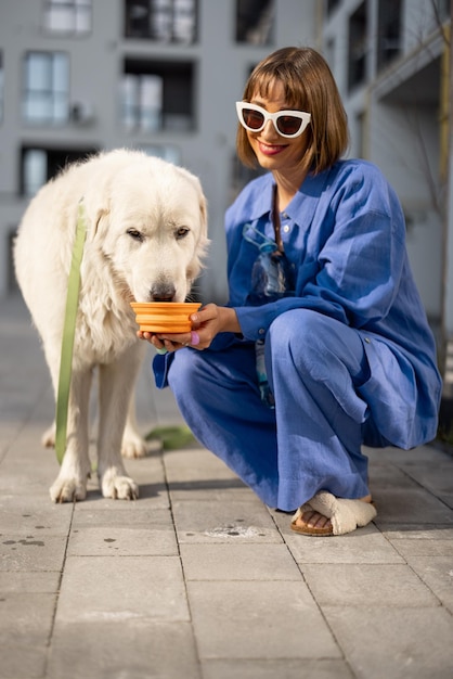 Photo woman gives water for her dog