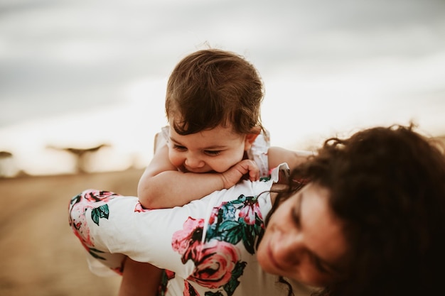 Photo woman giving baby girl piggyback