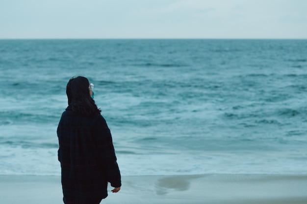 Женщина дает спину перед огромным океаном