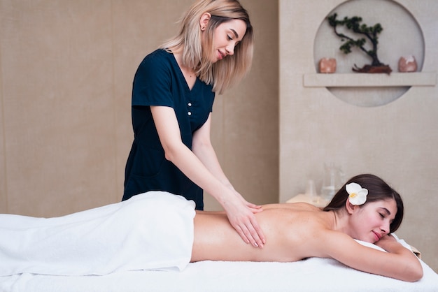 Woman giving back massage at spa