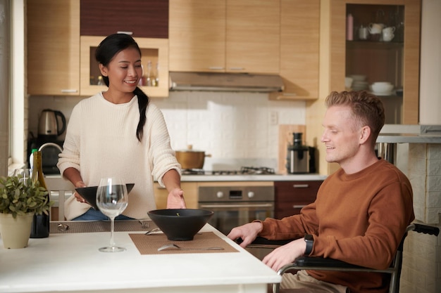 Photo woman giving bowl of salad to husband