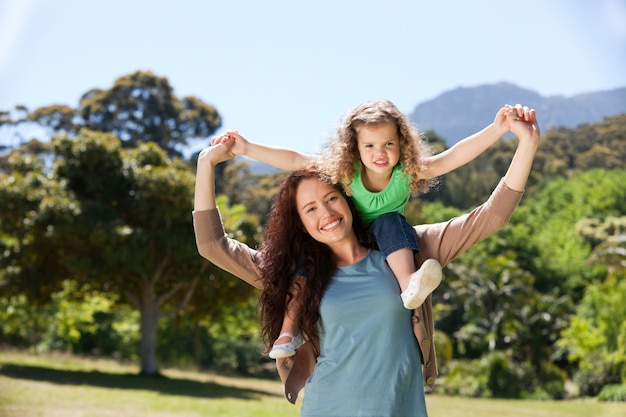 Woman giving daughter a piggyback