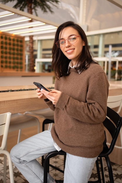 Woman in glasses holding smartphone
