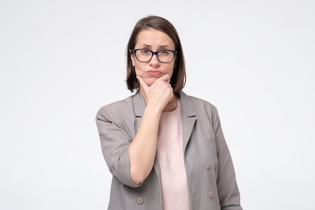 Woman in glasses looking aside with thoughtful look making plan for tomorrow