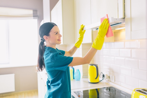 Woman in gloves cleaning the kitchen