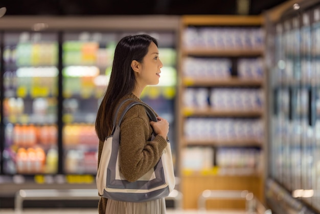 女性はスーパーマーケットに行って食料品を買う