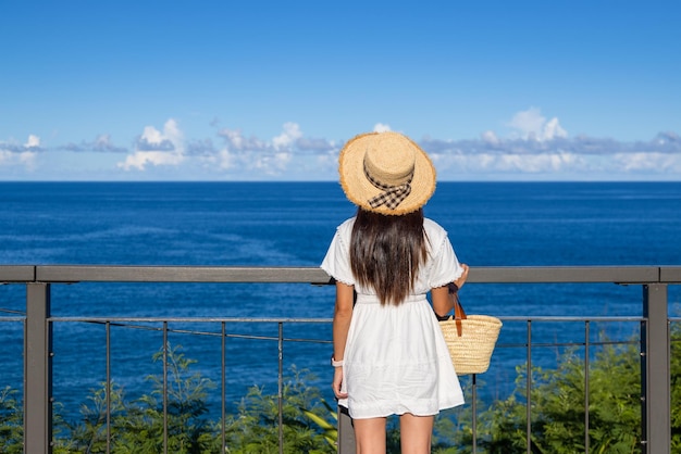 青い海の背景で旅をする女性