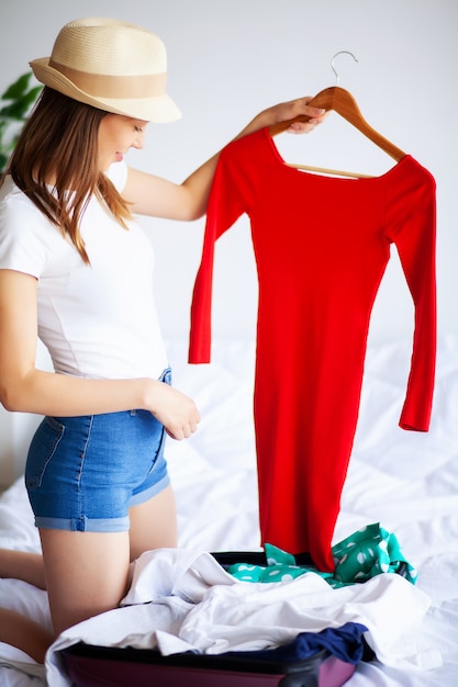 Woman goes on vacation and puts on clothes in suitcase