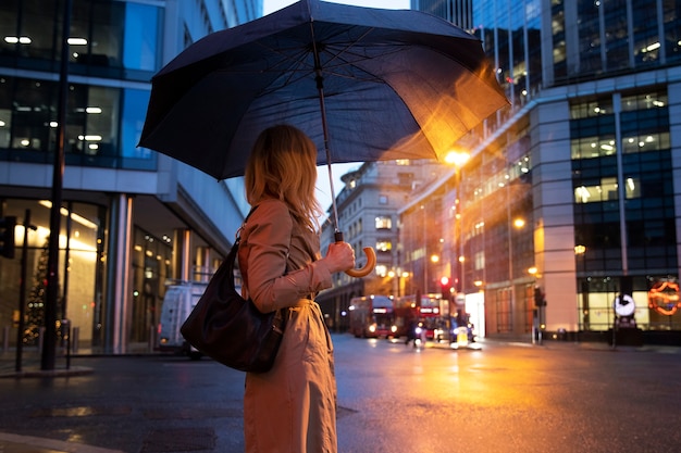 Photo woman going out in the city while it rains