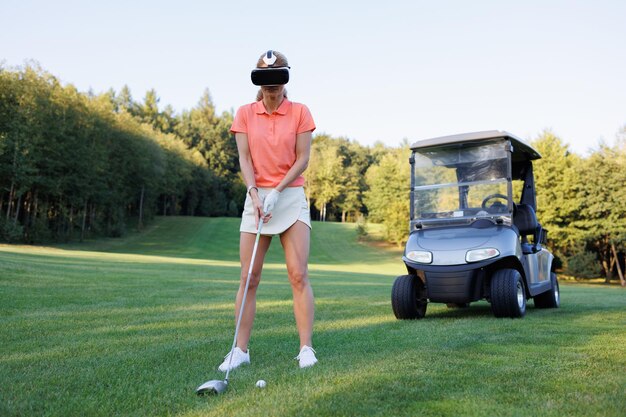 Woman Golfer in VR Glasses on Green with Golf Cart Behind