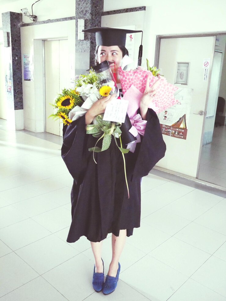 Photo woman in graduation gown standing in corridor