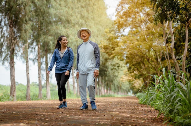 A woman and grandfather are walking jogging on the street at the park Grandfather talk