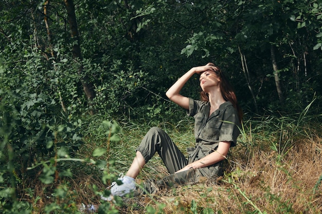 Woman on the grass with a raised hand and a jumpsuit