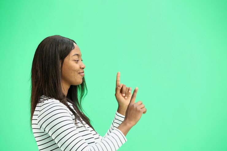 Photo a woman on a green background in closeup points to the side