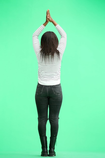 Foto una donna su uno sfondo verde in piena altezza applaude