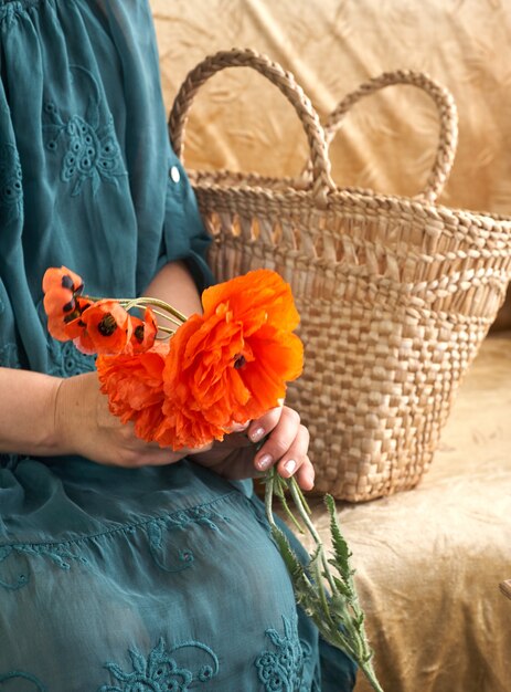 Woman in green dress holding poppe flowers close up on her hands spring time dreams